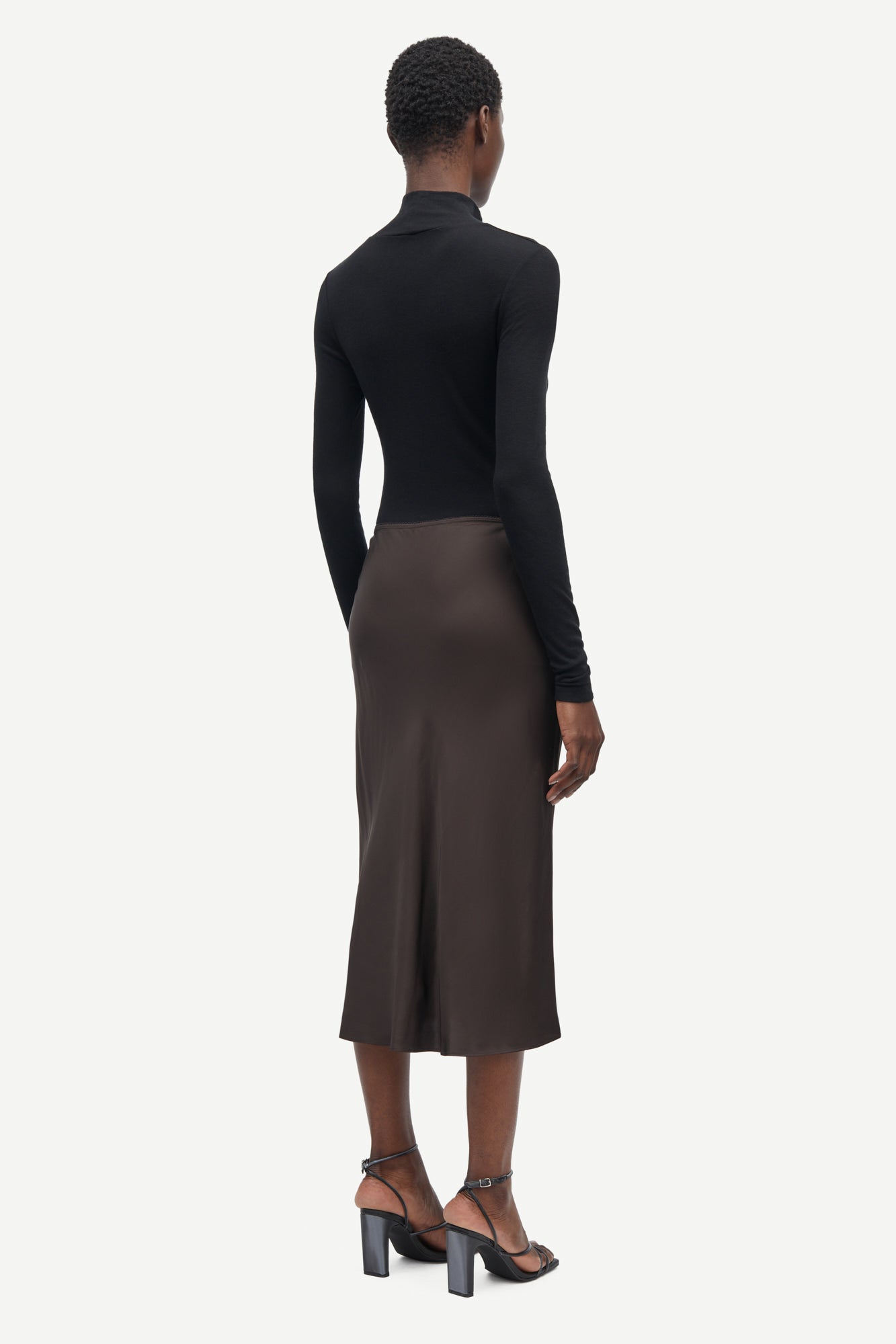Short mid length satin slip skirt in chocolate brown from samsoe samsoe rear view