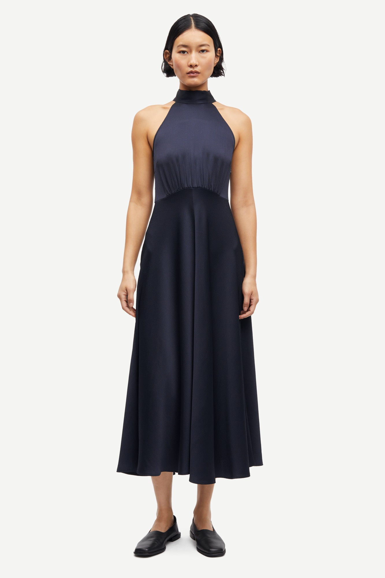 navy blue halterneck dress with open back and tie detail from samsoe samsoe model shot