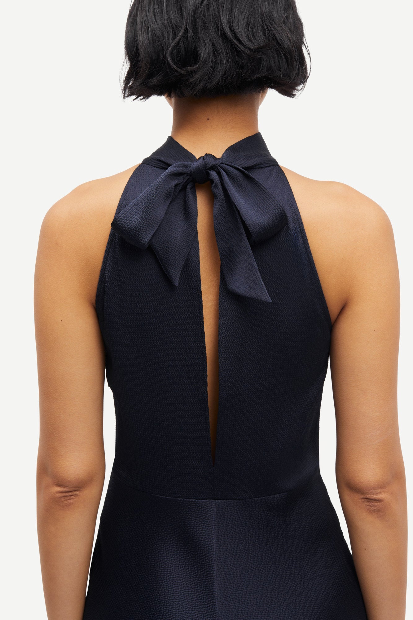 navy blue halterneck dress with open back and tie detail from samsoe samsoe rear view close up