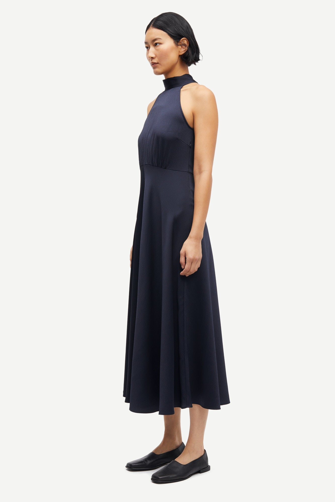 navy blue halterneck dress with open back and tie detail from samsoe samsoe side view