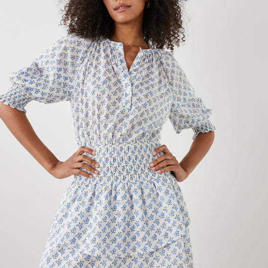 White and ditsy print dress with elbow length raglan sleeves ruched waist half placket with button fastening and crew neck with double layered short skirt