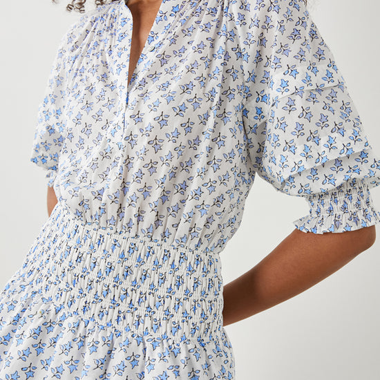 White and ditsy print dress with elbow length raglan sleeves ruched waist half placket with button fastening and crew neck with double layered short skirt