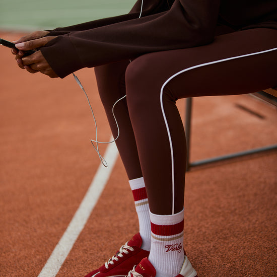high rise brown leggings with white piping on the side from varley model shot