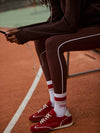 high rise brown leggings with white piping on the side from varley model shot