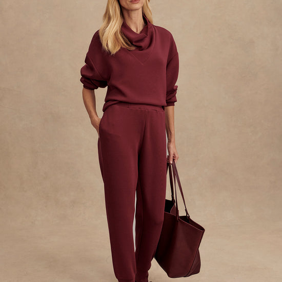 Slim fit maroon coloured sweat pants with ankle cuff and elasticated waistband model shot