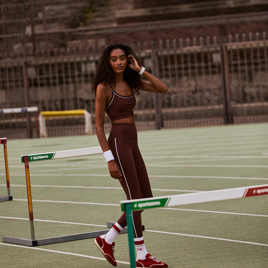high rise brown leggings with white piping on the side from varley model shot