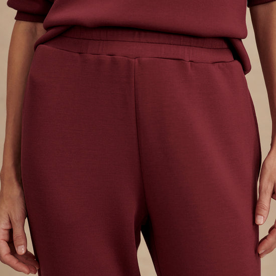 Slim fit maroon coloured sweat pants with ankle cuff and elasticated waistband close up