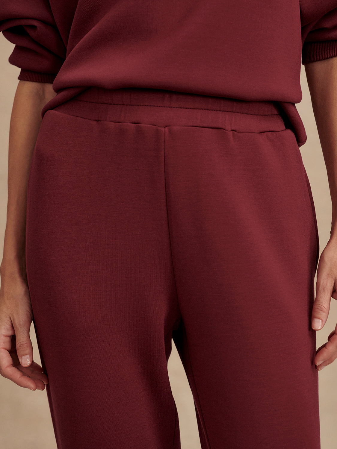 Slim fit maroon coloured sweat pants with ankle cuff and elasticated waistband close up
