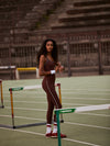 high rise brown leggings with white piping on the side from varley model shot
