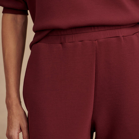 Slim fit maroon coloured sweat pants with ankle cuff and elasticated waistband close up