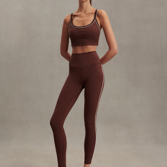 high rise brown leggings with white piping on the side from varley model shot
