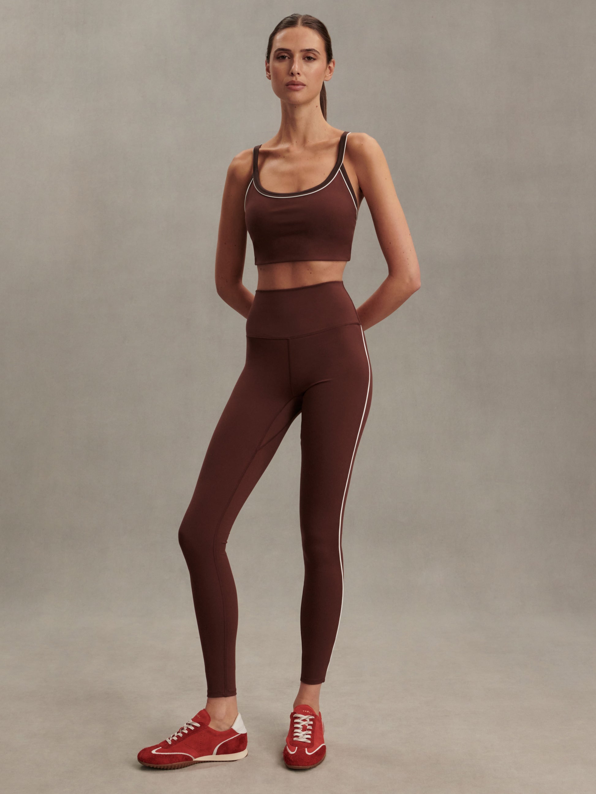 high rise brown leggings with white piping on the side from varley model shot