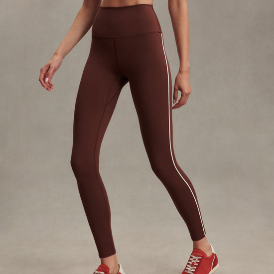 high rise brown leggings with white piping on the side from varley model shot