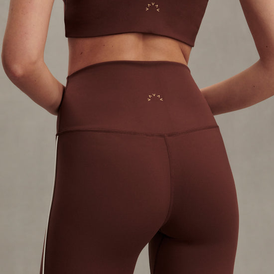 high rise brown leggings with white piping on the side from varley close up