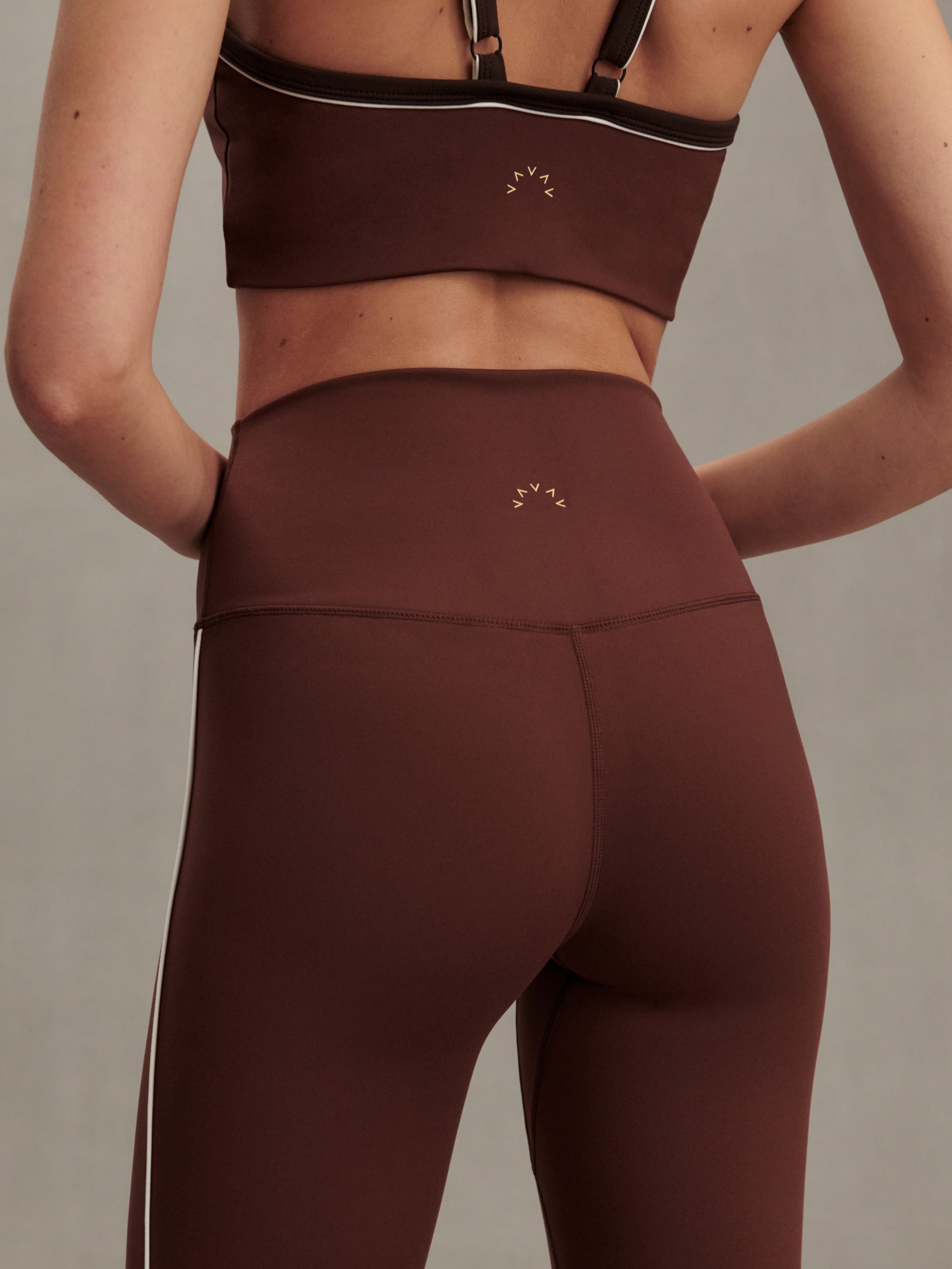 high rise brown leggings with white piping on the side from varley close up