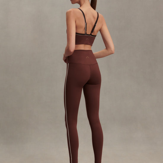 high rise brown leggings with white piping on the side from varley rear view