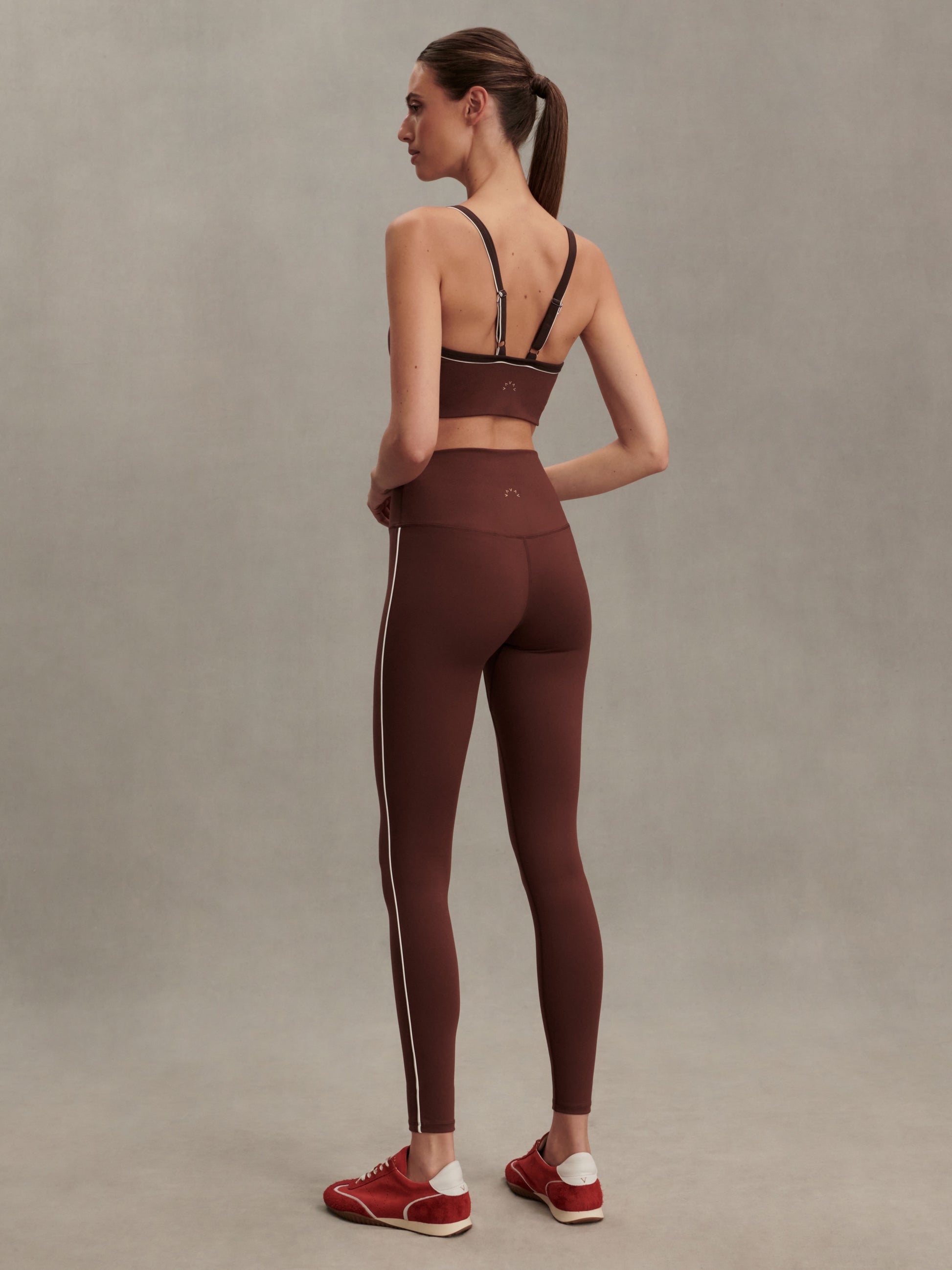 high rise brown leggings with white piping on the side from varley rear view
