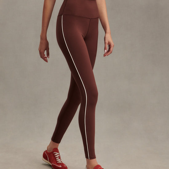 high rise brown leggings with white piping on the side from varley