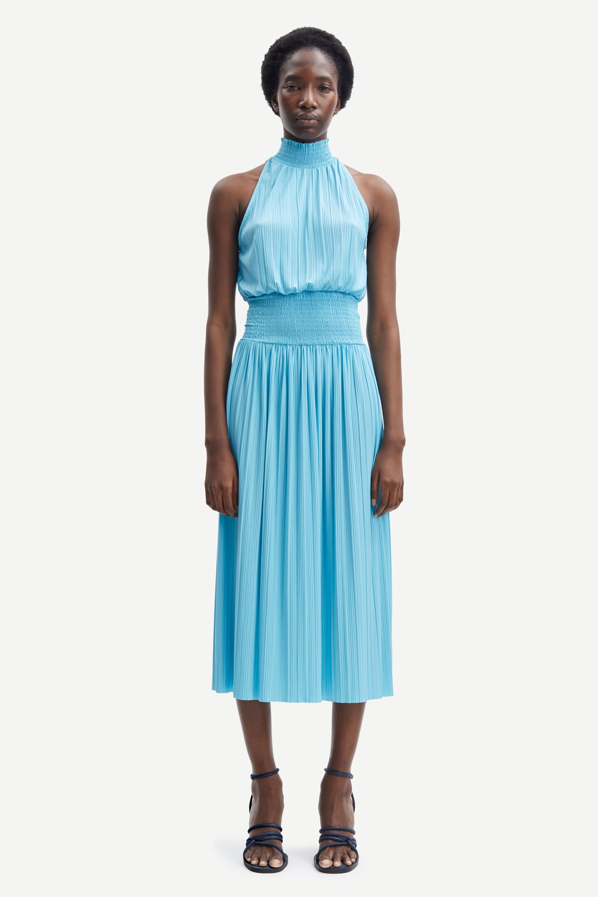 Light blue halterneck top with ruched waist and light pleats throughout midi in length