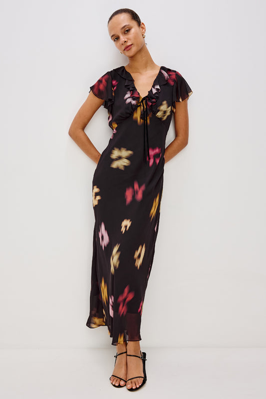 v neck long black dress with ruffled neckline and sleeves with floral blurred print model shot