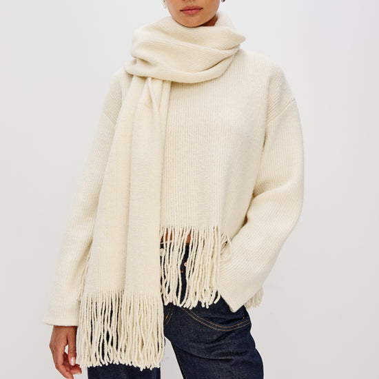 high neck ivory wool jumper with fringe along the hemline model shot