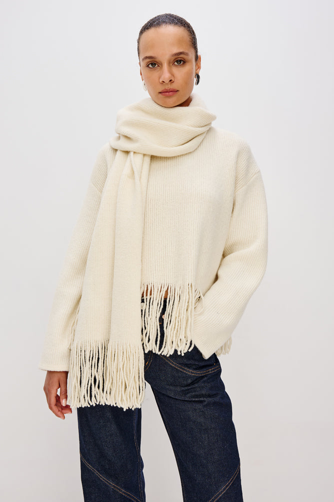 high neck ivory wool jumper with fringe along the hemline model shot