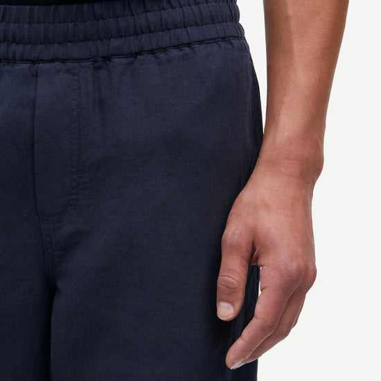 Navy blue pants worn by a person on a white background