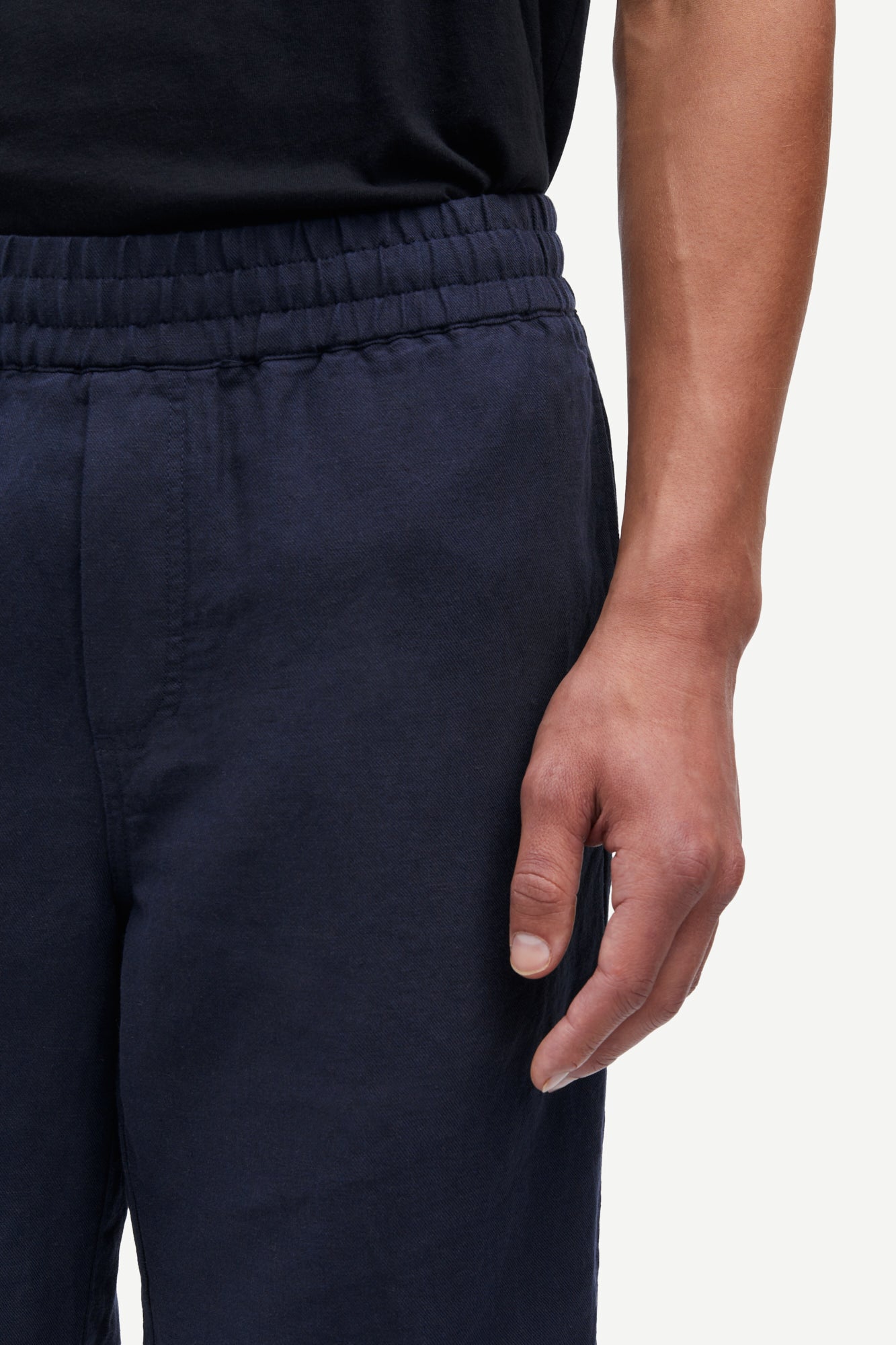 Navy blue pants worn by a person on a white background