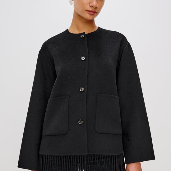 short black wool coat with patch pockets on front and fringe detailing along the hem
