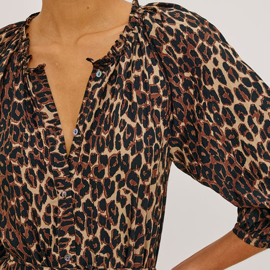 Leopard print dress worn by a person on a plain background