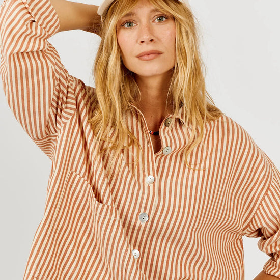 Model wearing a vertical stripe shirt on a white background 