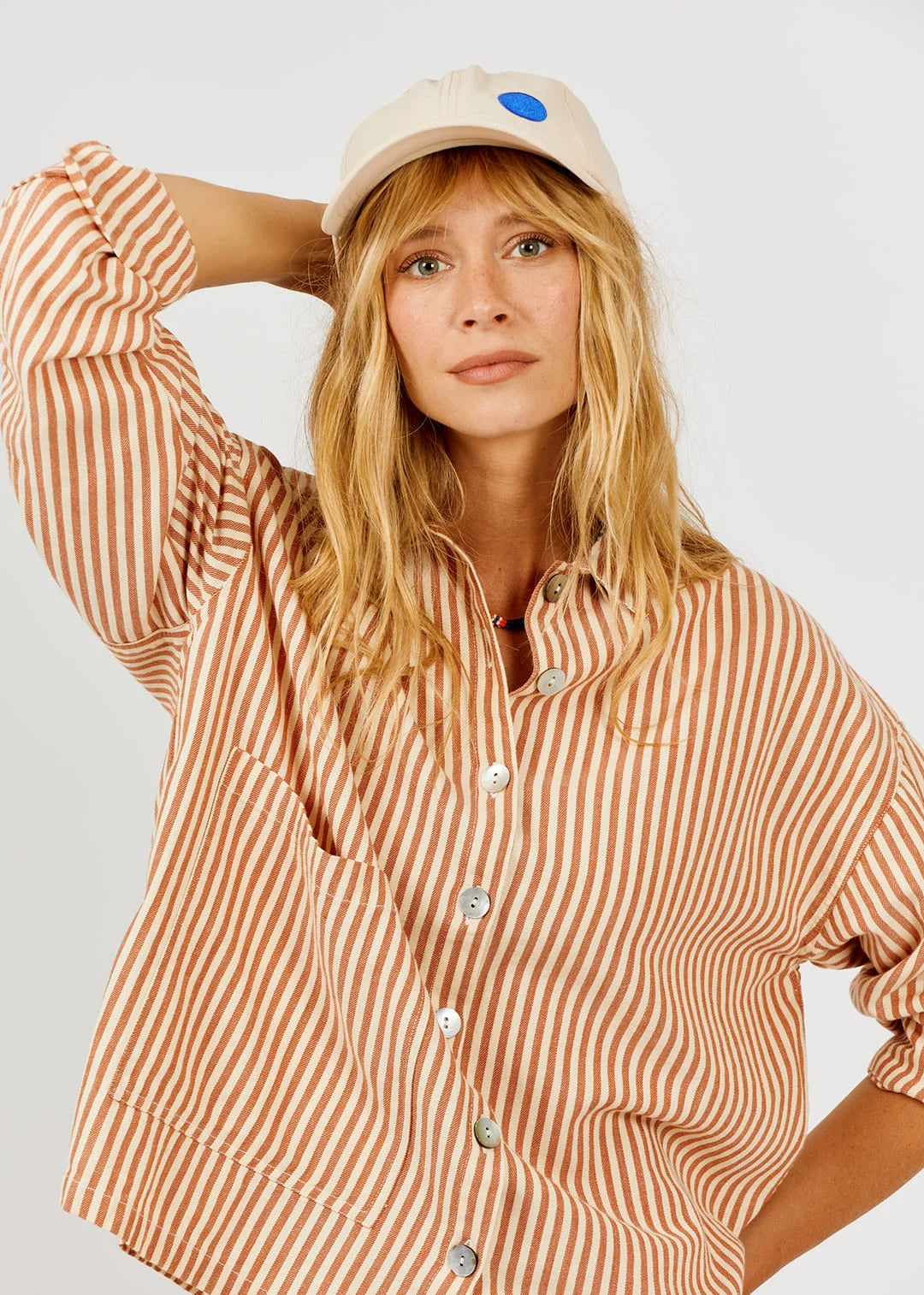 Model wearing a vertical stripe shirt on a white background 