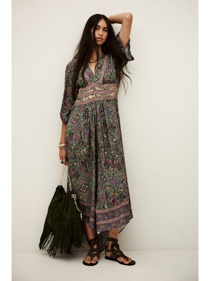 Woman wearing a patterned dress with a plain background