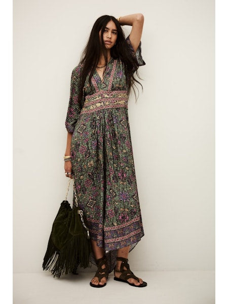 Woman wearing a patterned dress with a plain background