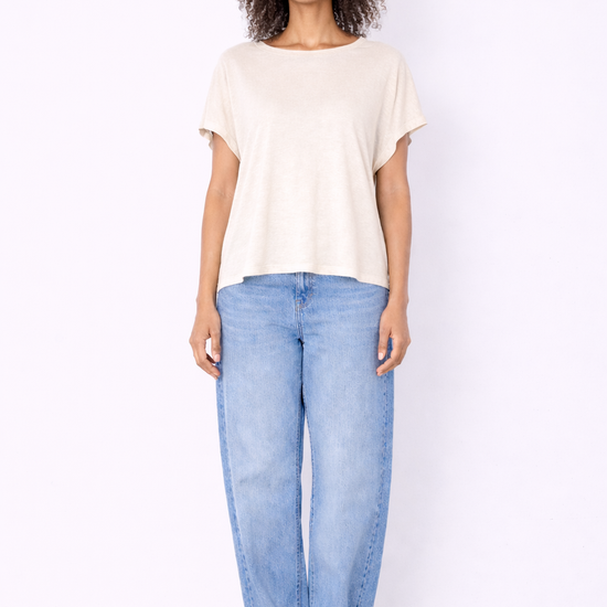 Woman wearing a white t-shirt and light blue jeans on a white background