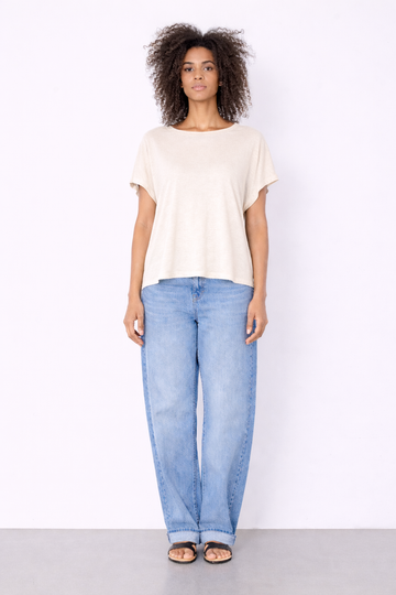 Woman wearing a white t-shirt and light blue jeans on a white background
