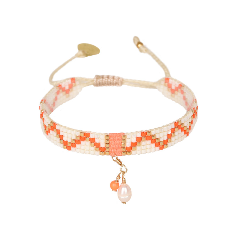 Cream and orange beaded bracelet with gold highlights and a pearl charm