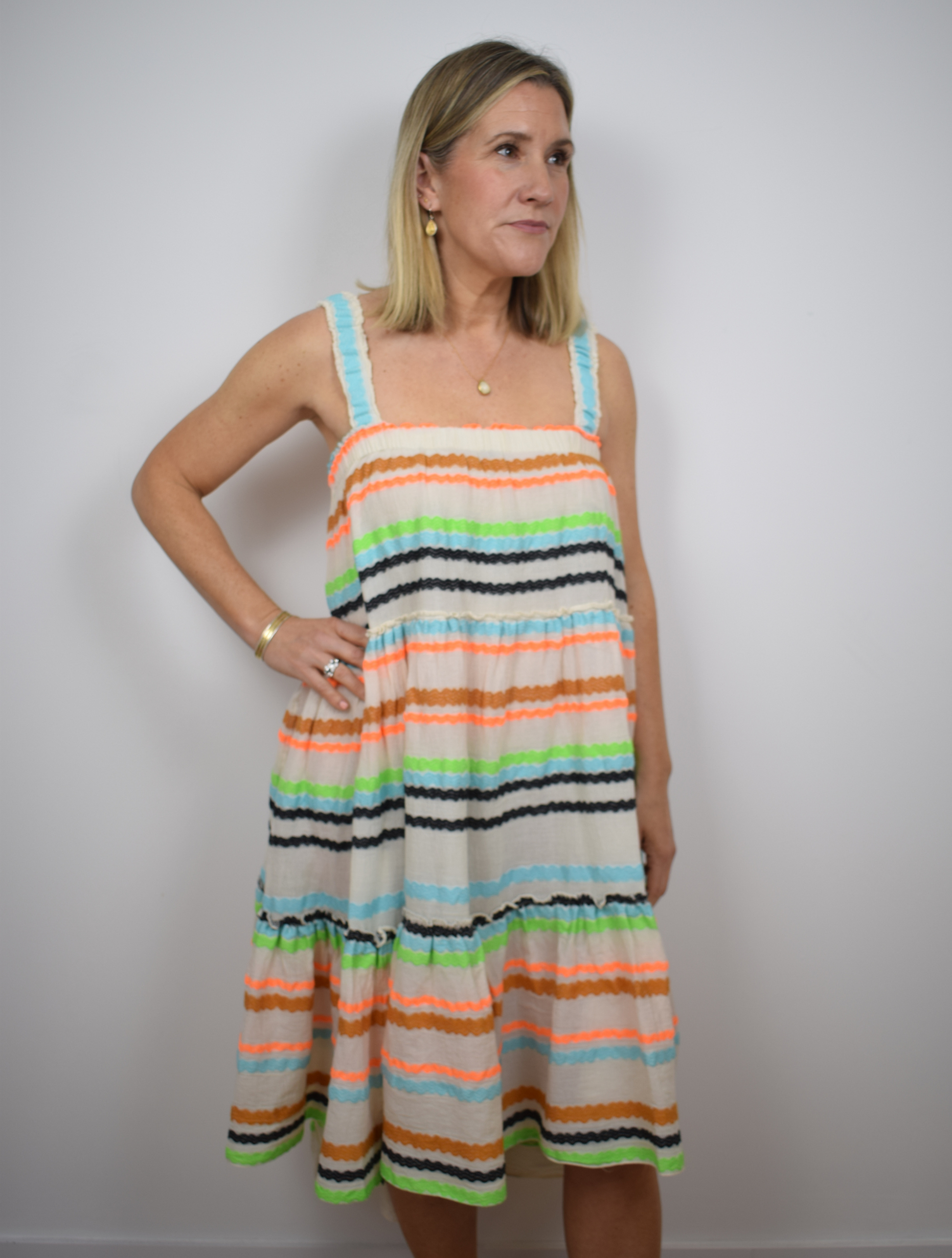 Ecru dress with blue, black, orange and brown frill stripes 