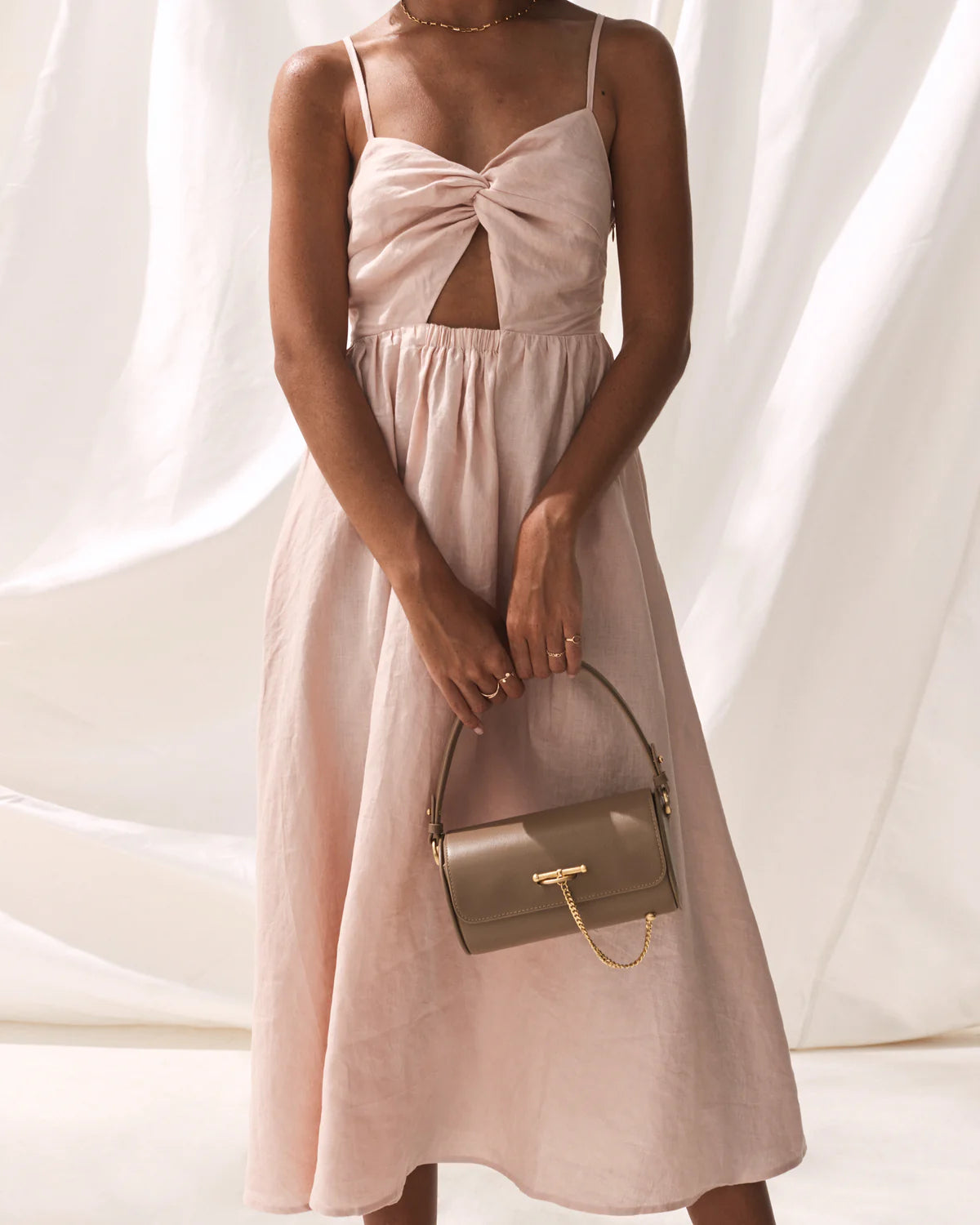 Blush pink dress with spaghetti straps knotted front midi skirt and criss cross tie detail at the back