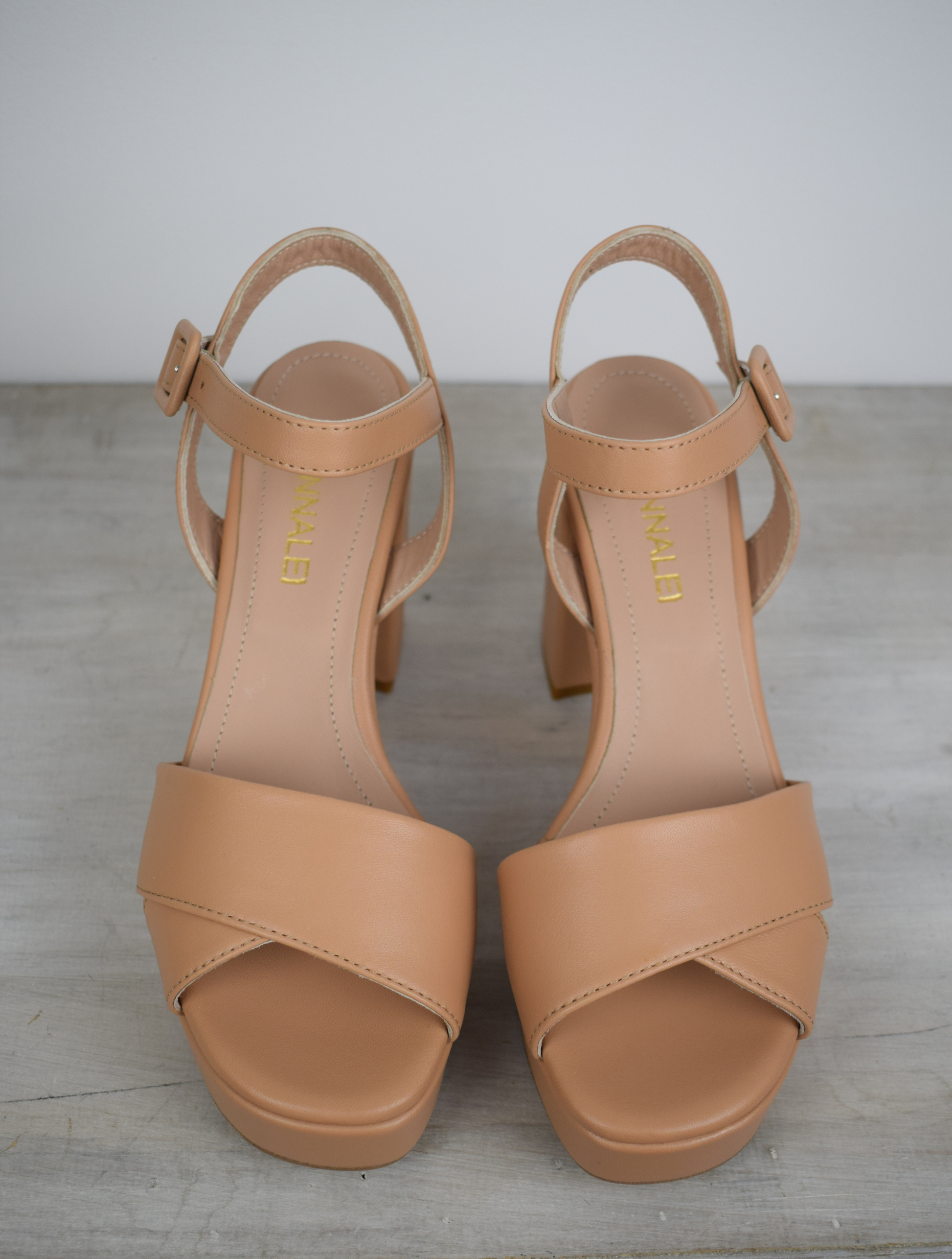 Nude leather platform sandal with cross straps and ankle strap with buckle fastening