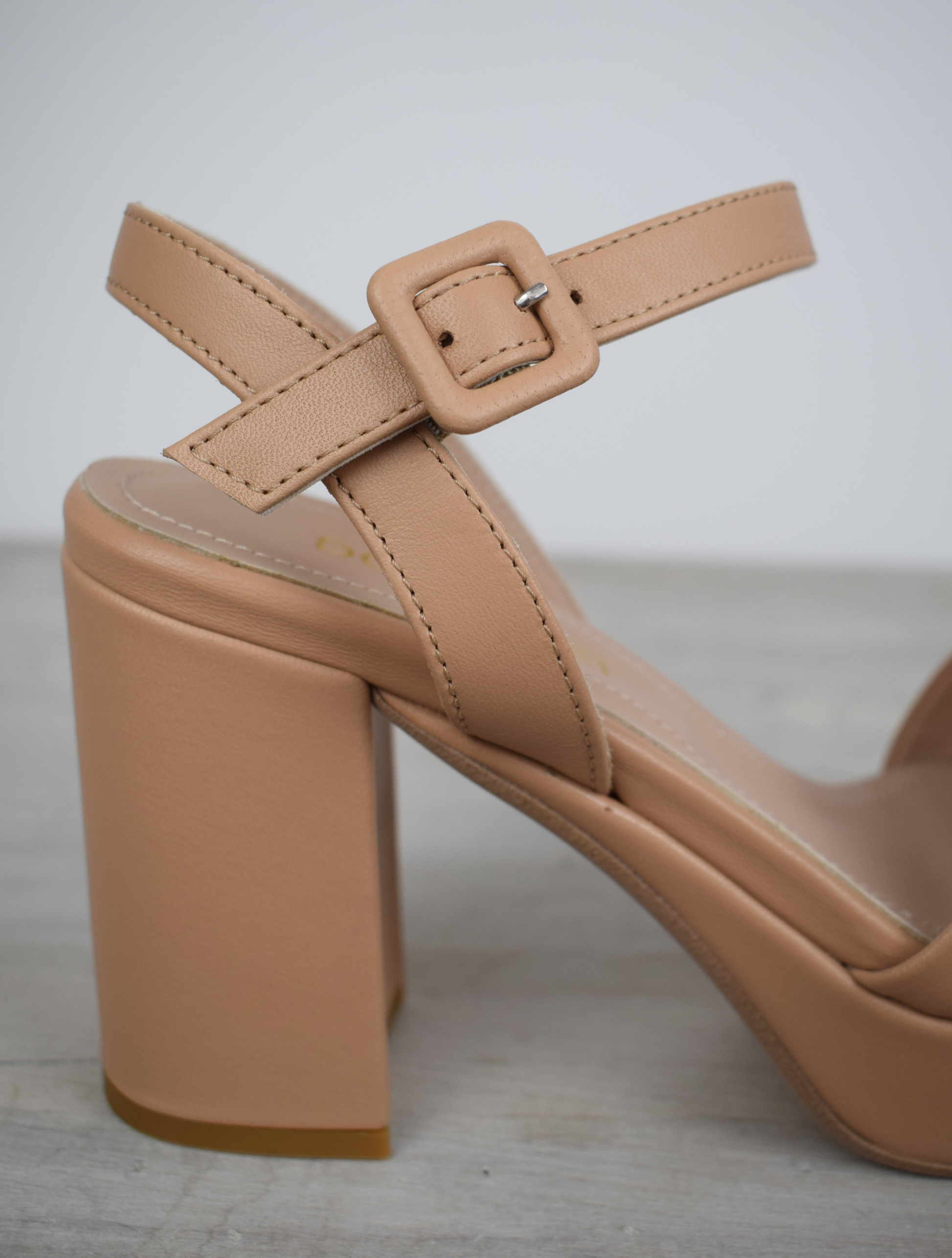 Nude leather platform sandal with cross straps and ankle strap with buckle fastening