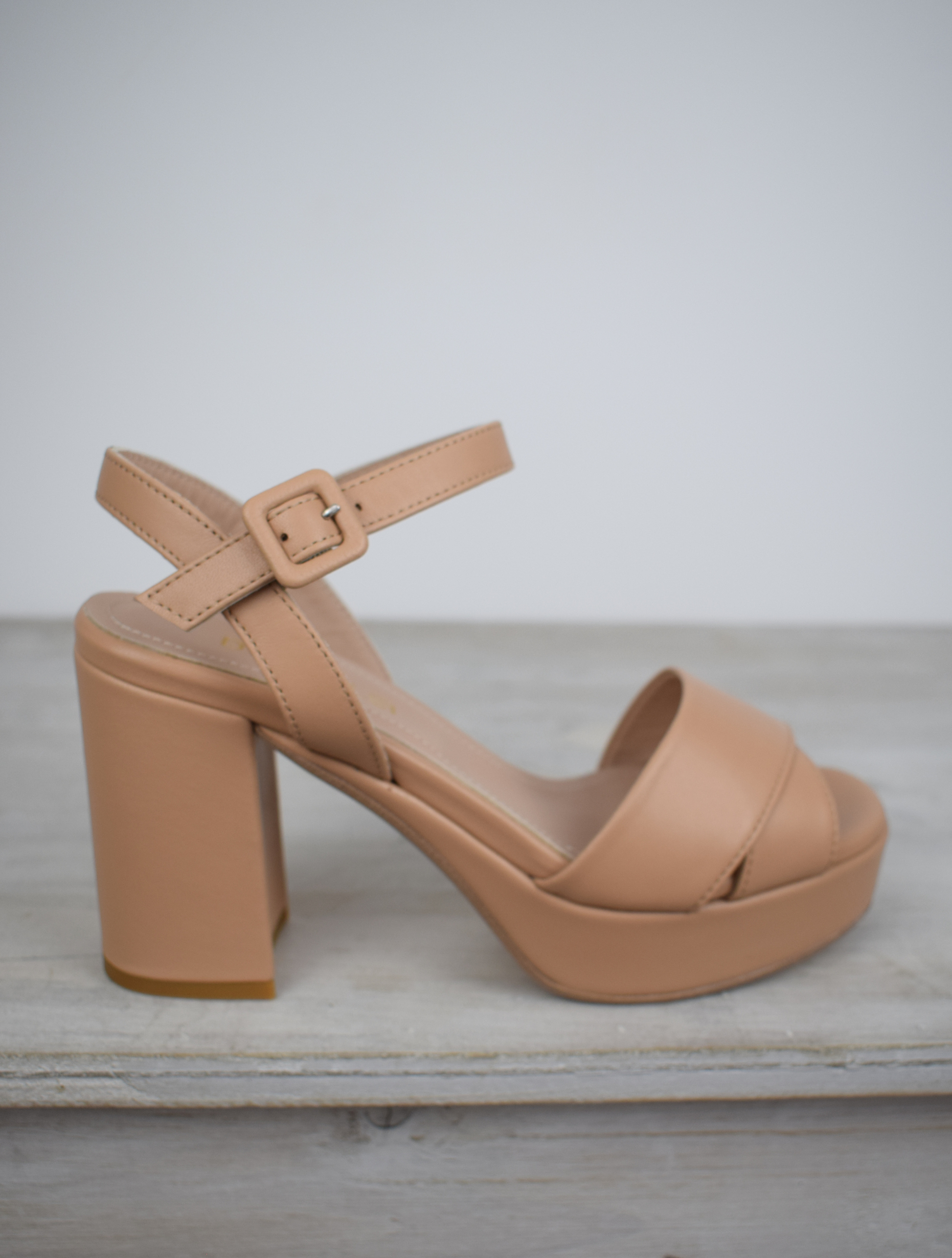 Nude leather platform sandal with cross straps and ankle strap with buckle fastening