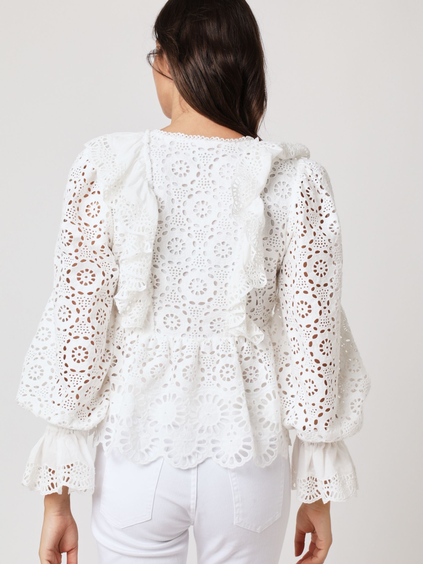 White lace top with V neck and ruffles, long sleeves with elasticated cuffs and deep frill details