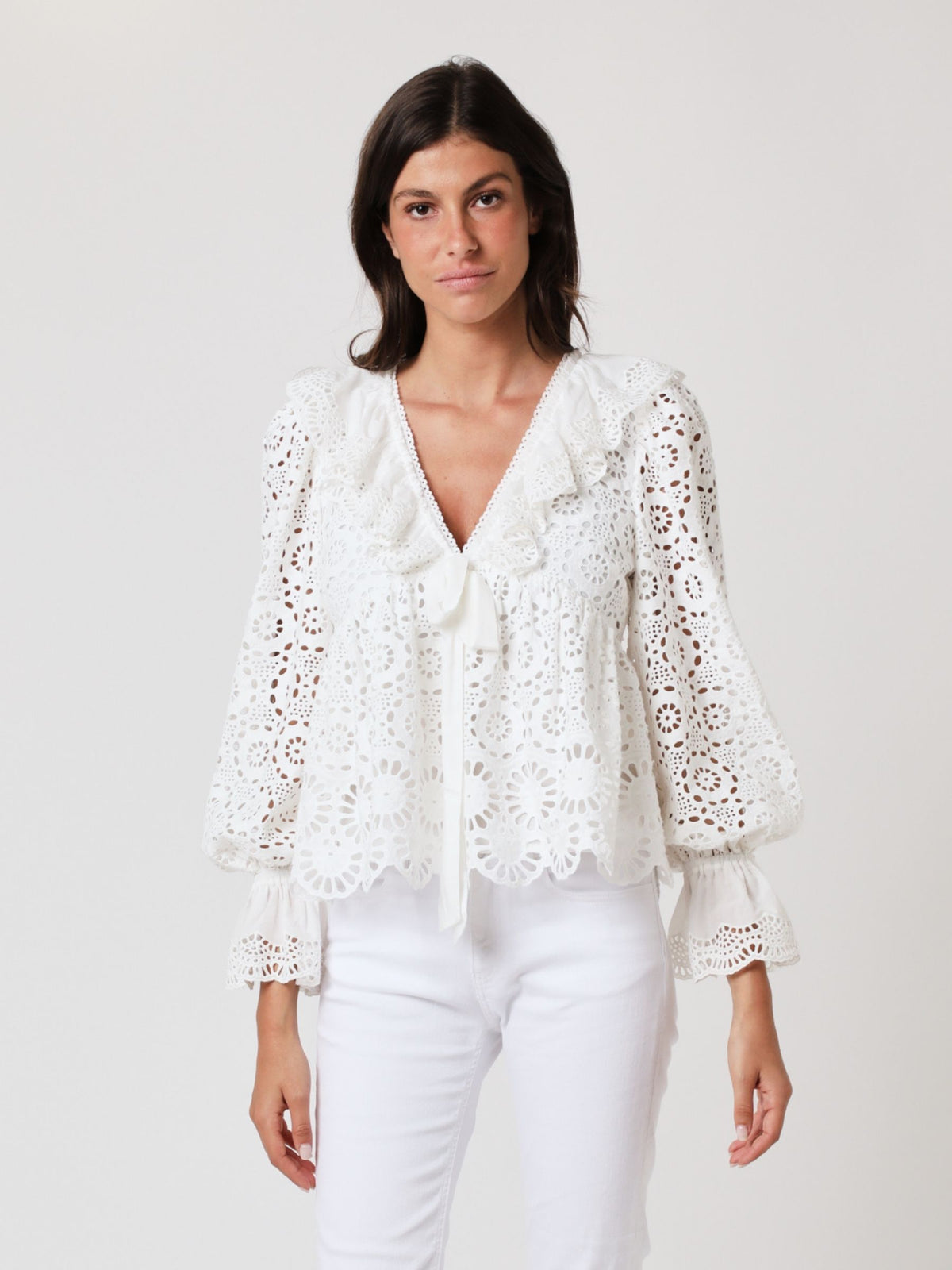 White lace top with V neck and ruffles, long sleeves with elasticated cuffs and deep frill details