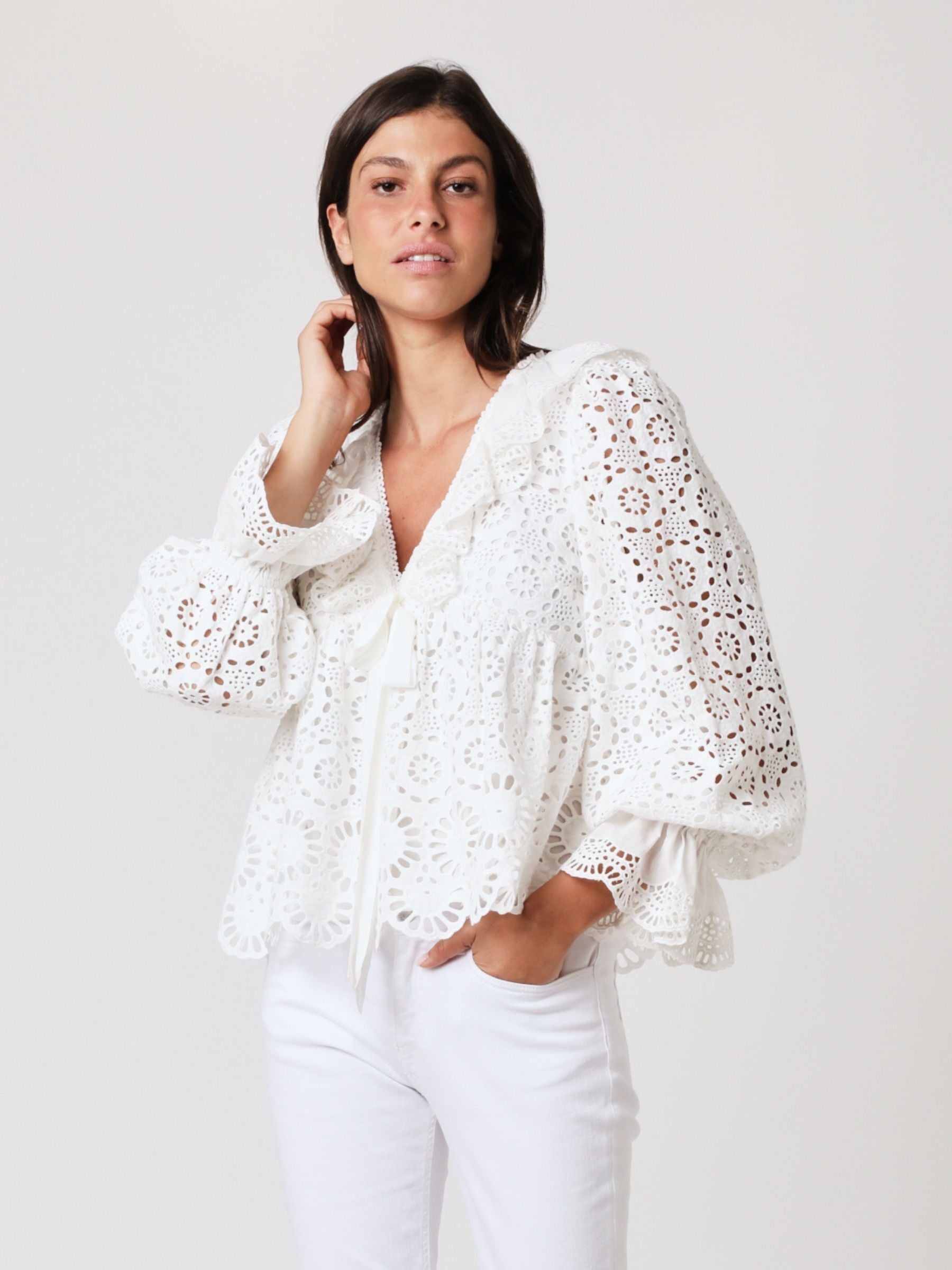 White lace top with V neck and ruffles, long sleeves with elasticated cuffs and deep frill details