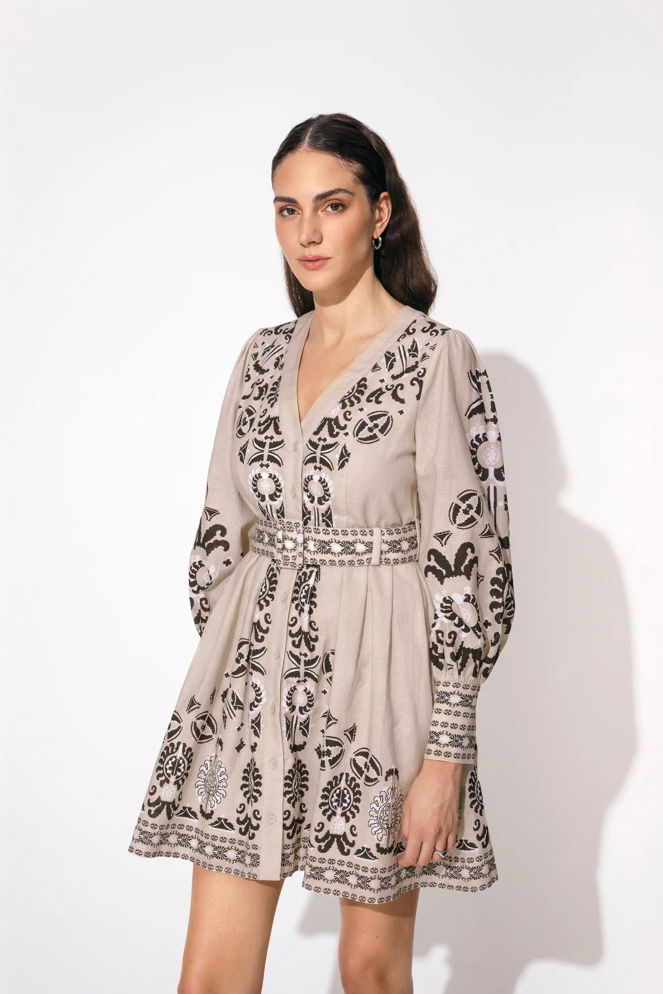 A line mini dress in taupe with fabric belt and abstract black and ecru print v neck with long sleeves and contrast belt hem and cuffs