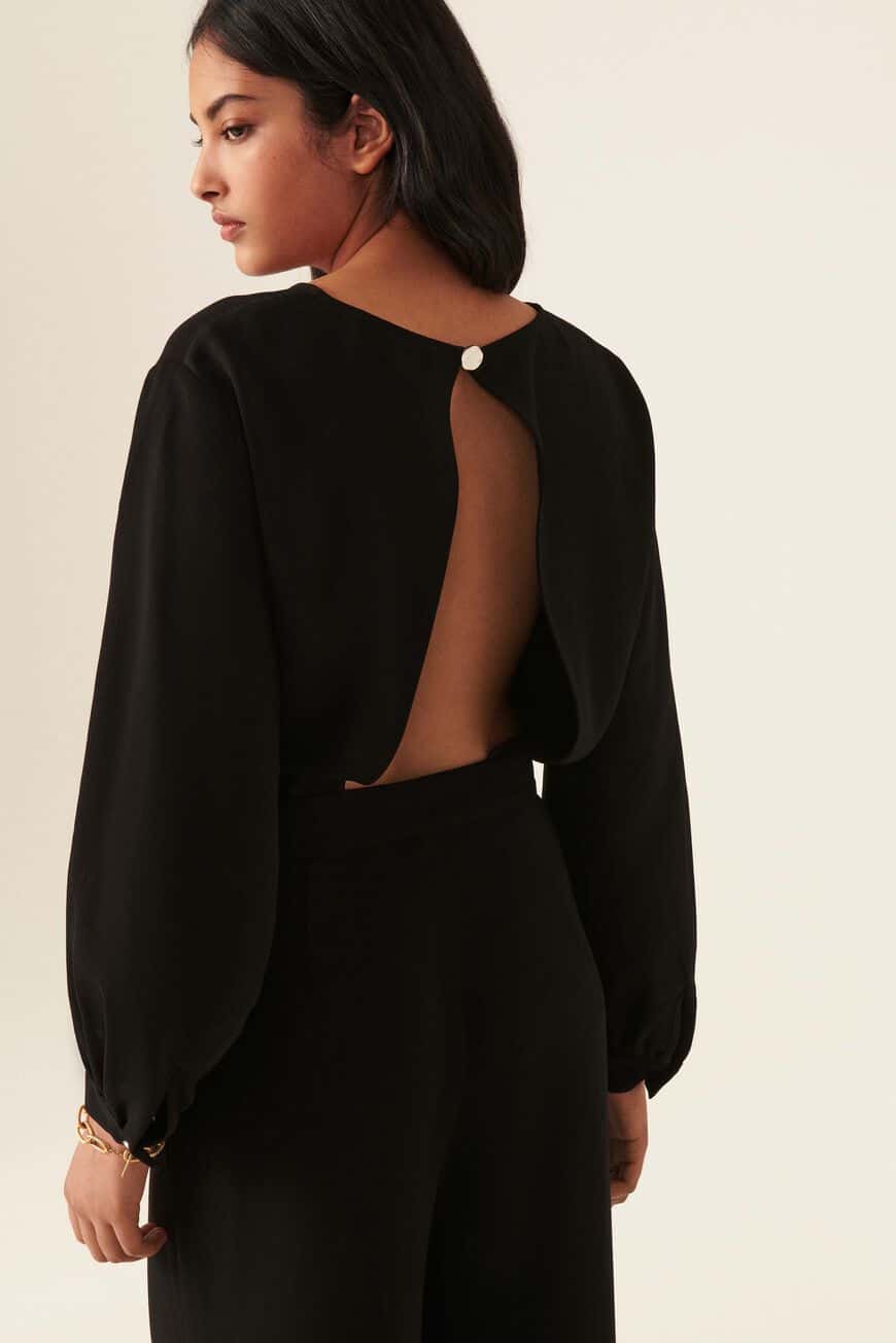 Crepe black long-sleeved jumpsuit with long sleeves and an open inverted V back.