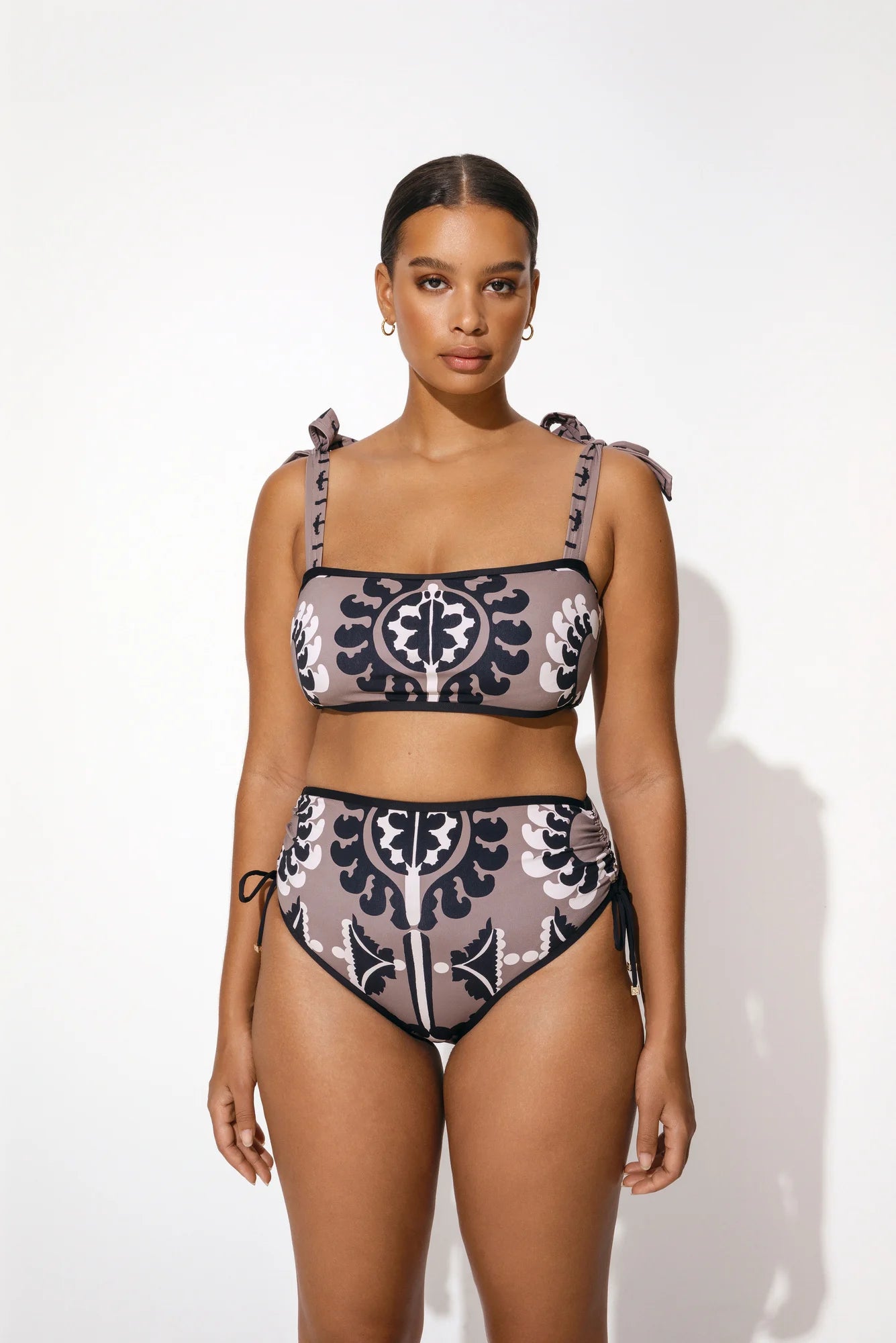 High waisted bikini bottoms in taupe with black and ecru folk inspired motif print and drawstring sides