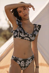 Bikini top with V neckline and ruffle detail in black print with taupe and ecru motif print