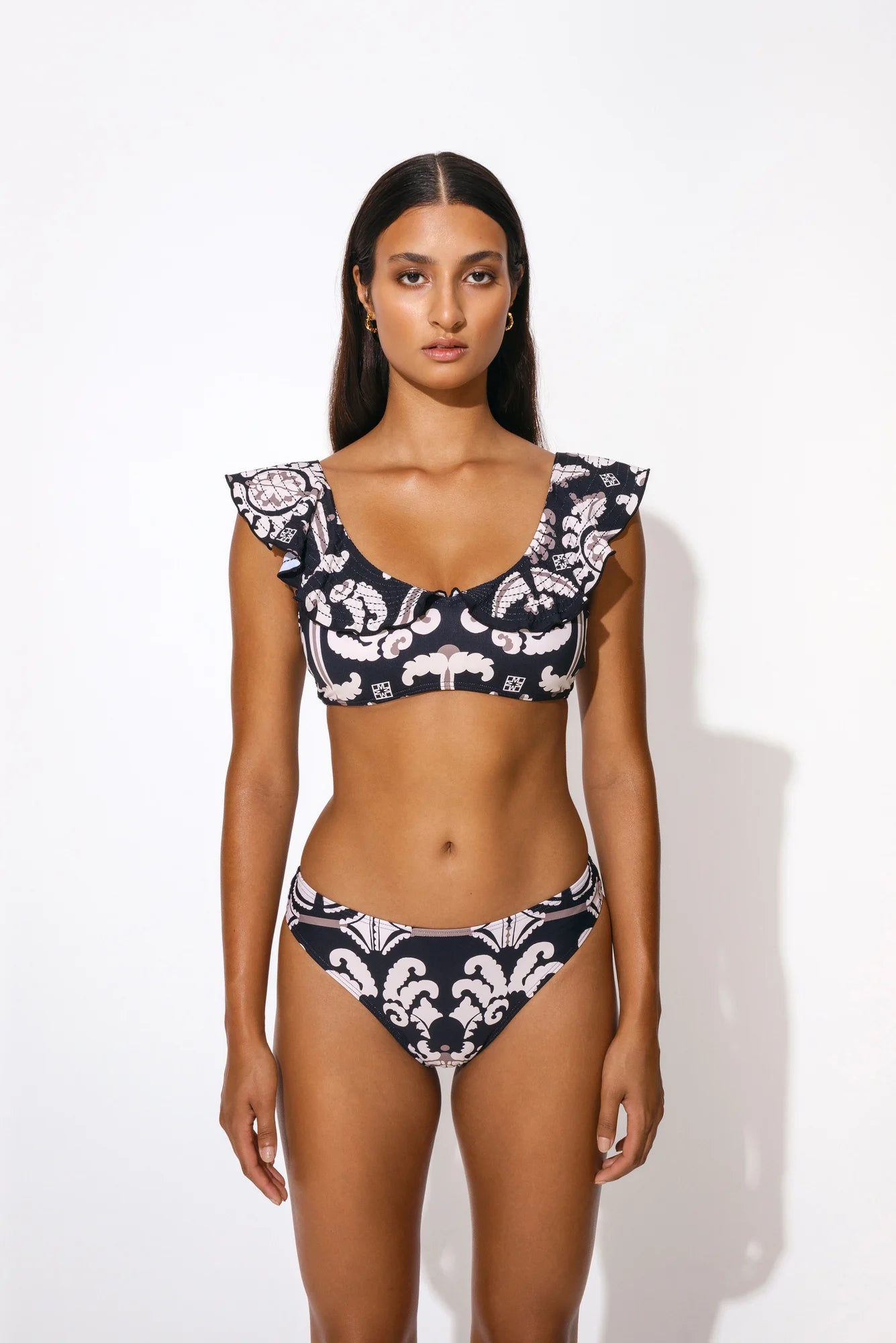 Bikini top with V neckline and ruffle detail in black print with taupe and ecru motif print